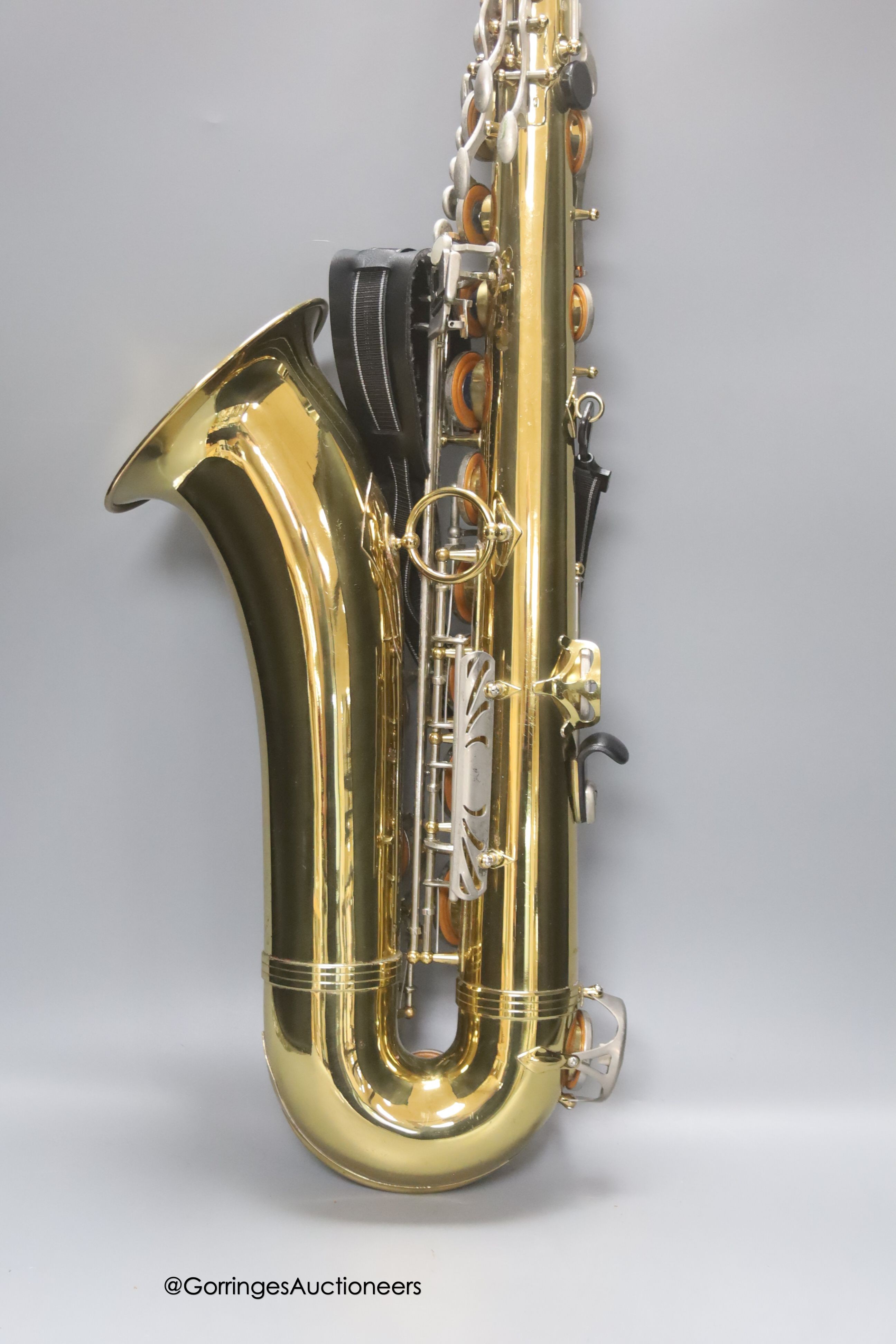 A cased Earlham brass saxophone and music sheets